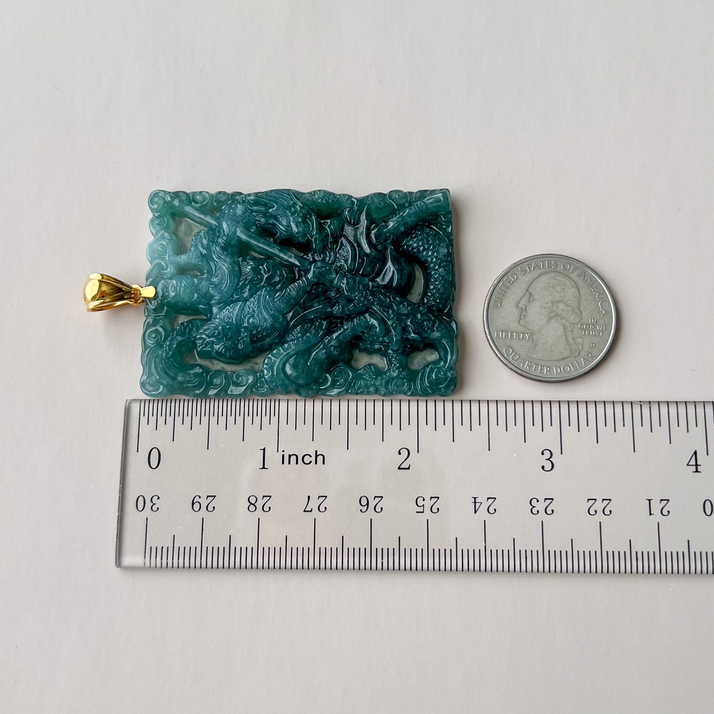 Green jadeite Guan Gong warrior pendant with 18K gold bail, carved relief, glossy finish, shown with ruler and quarter for sc