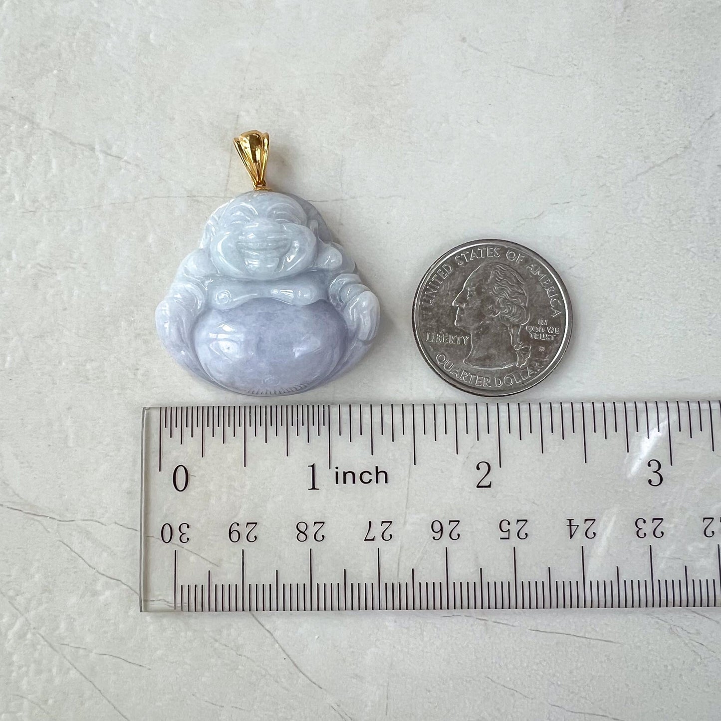 Lavender jadeite Happy Buddha pendant with 18k gold bail, glossy carved finish, shown beside quarter and ruler