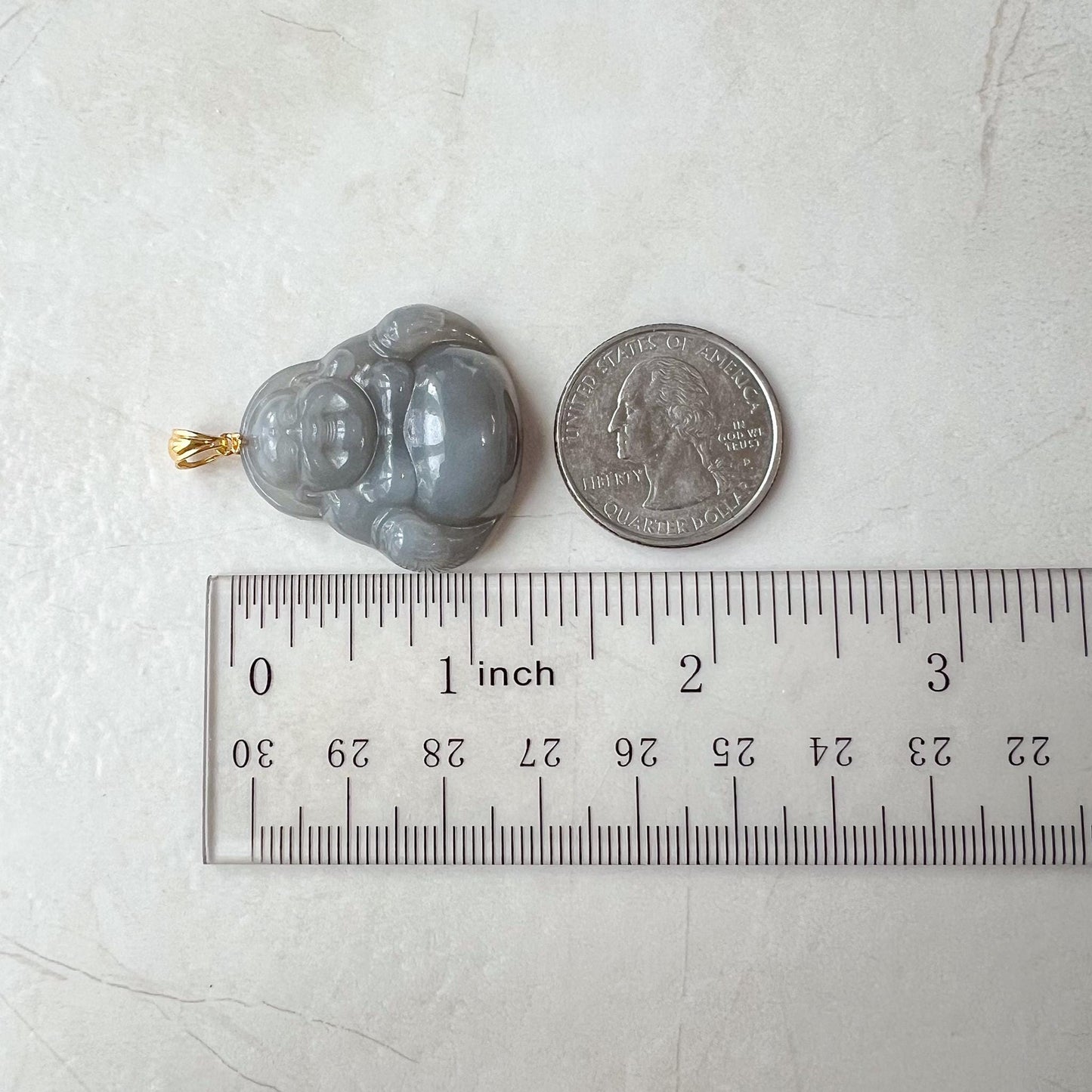 Smokey purple gray nephrite jade Happy Buddha pendant with glossy carved finish and 18K gold bail beside a quarter for scale