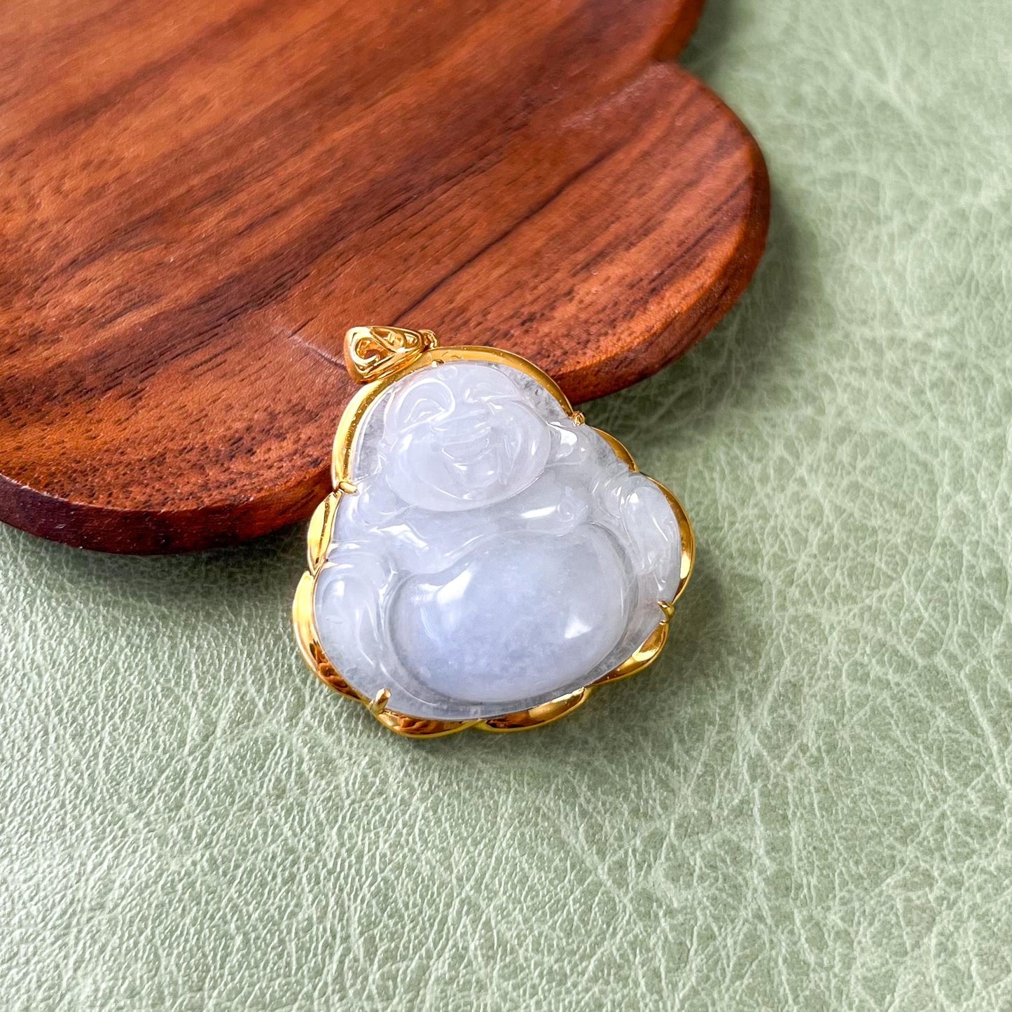 Happy Buddha light lavender jadeite pendant in 18k gold, close-up angled view with glossy carved finish and textured backdrop