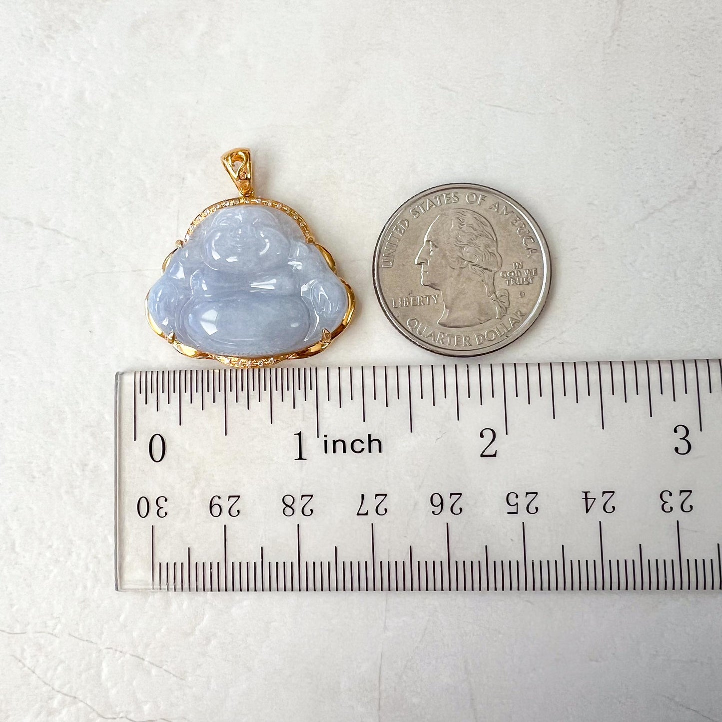 Lavender jadeite Happy Buddha pendant in 18k gold, glossy carved finish shown beside a quarter and ruler for scale