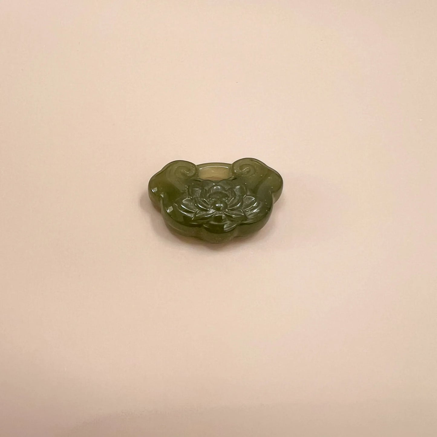 Green nephrite jade lotus ruyi pendant, front view, glossy carved floral detail, polished translucent finish