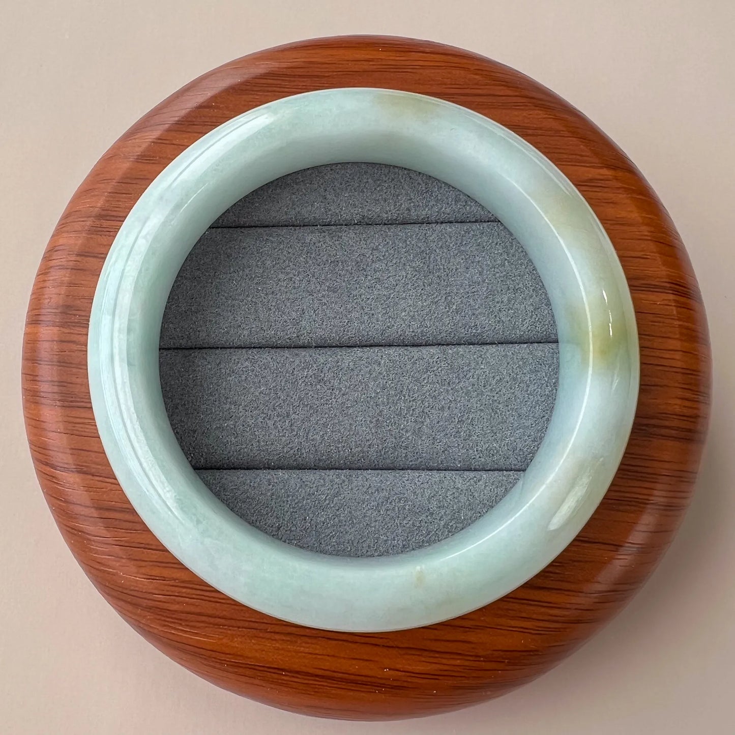 Top view of pale green natural jade bangle showing rounded profile and polished inner surface
