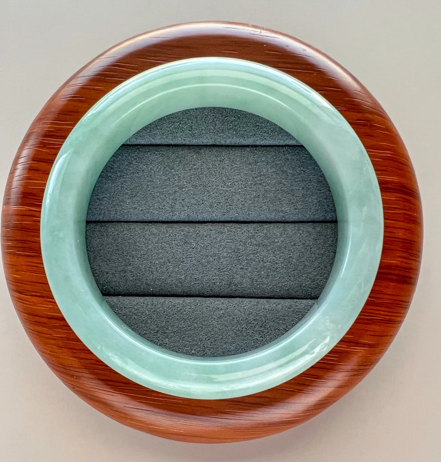 Front view of translucent jade bangle on padded display cushion