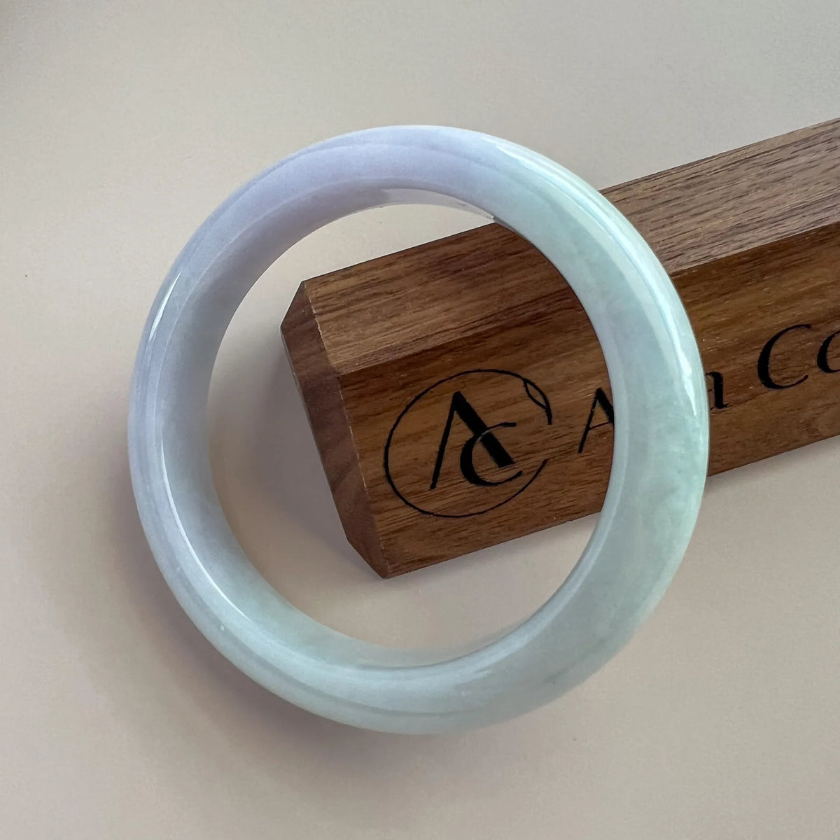Front view of pale blue jade bangle with glossy polished finish on neutral background