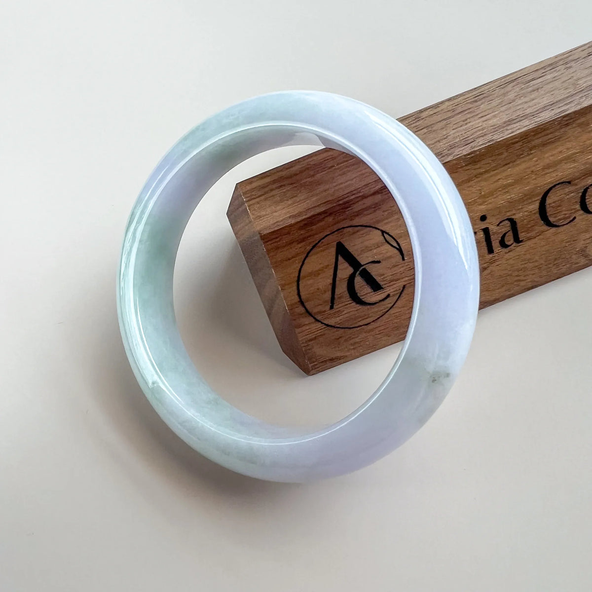 Front view of polished pale lavender and green jade bangle on white background