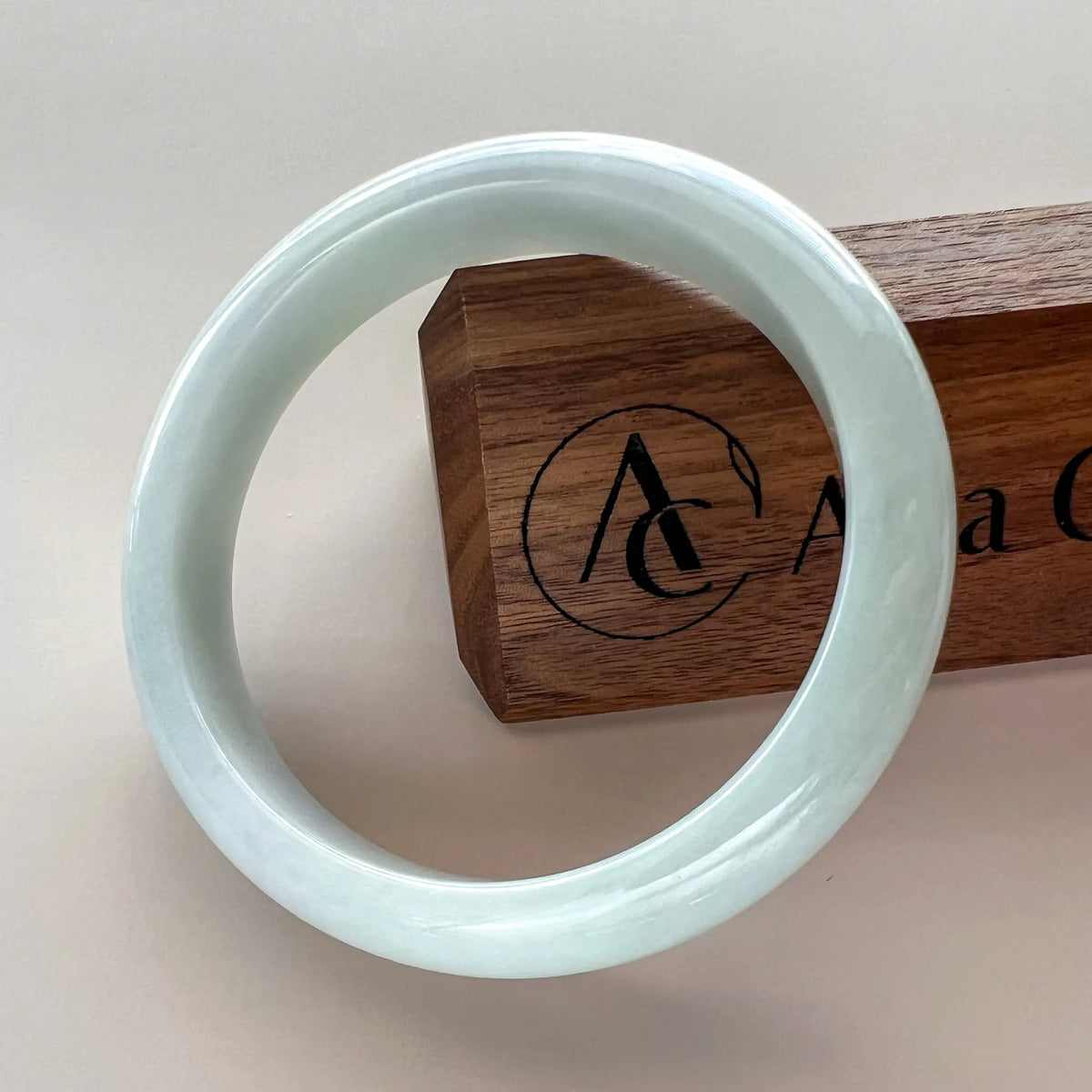 Side angle of polished jade bangle with branded wooden box