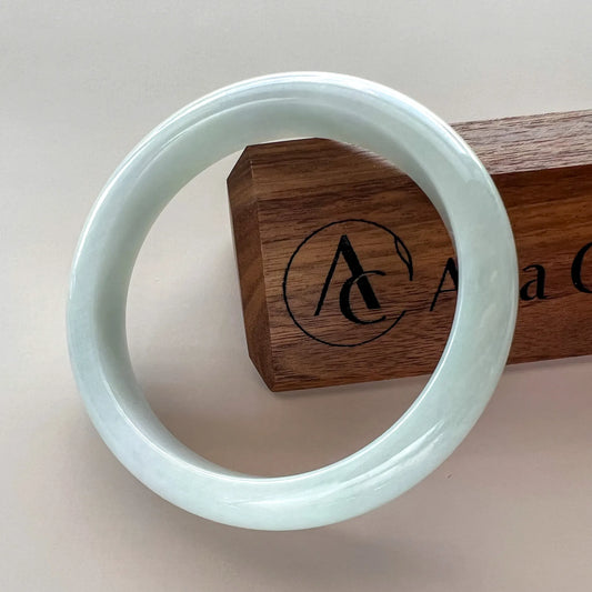 Side angle of polished jade bangle with branded wooden box