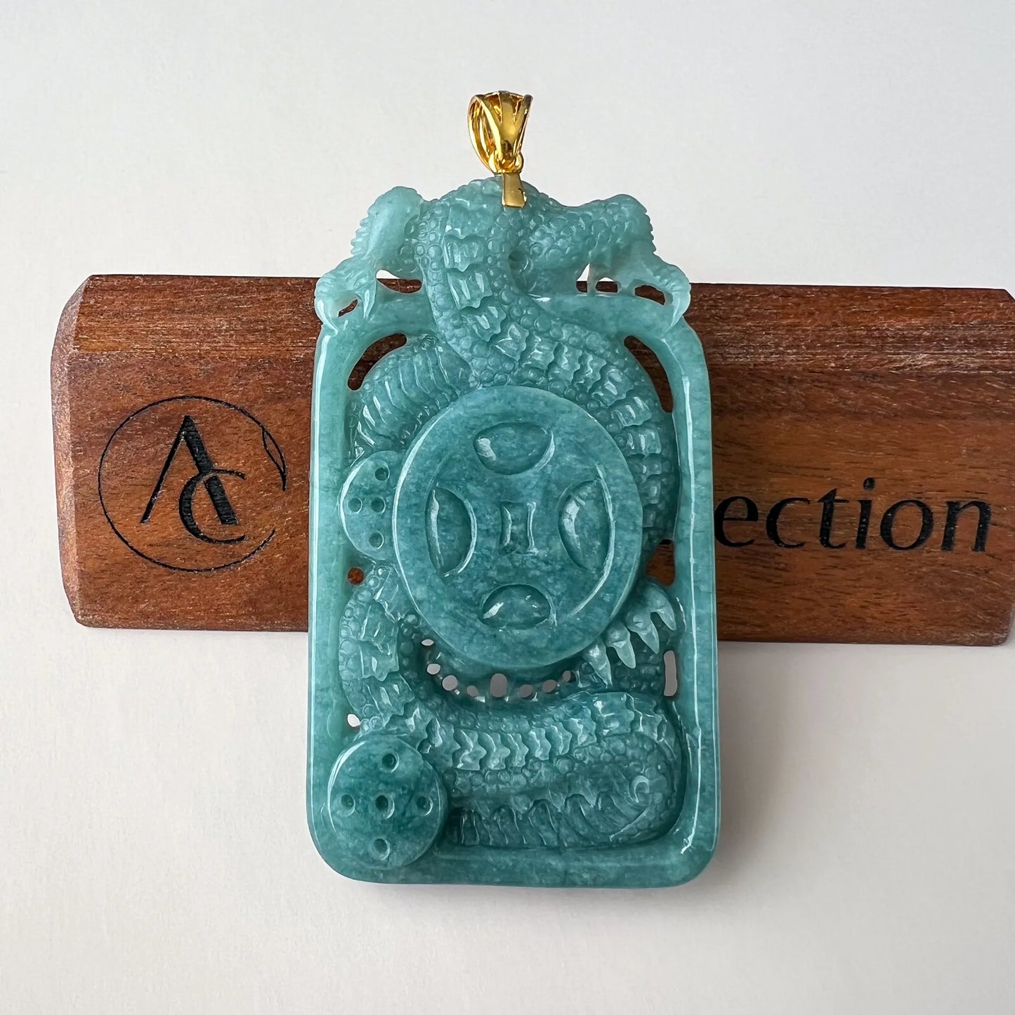 Back view showing dragon body, coin-style medallion, pierced details and gold-tone bail