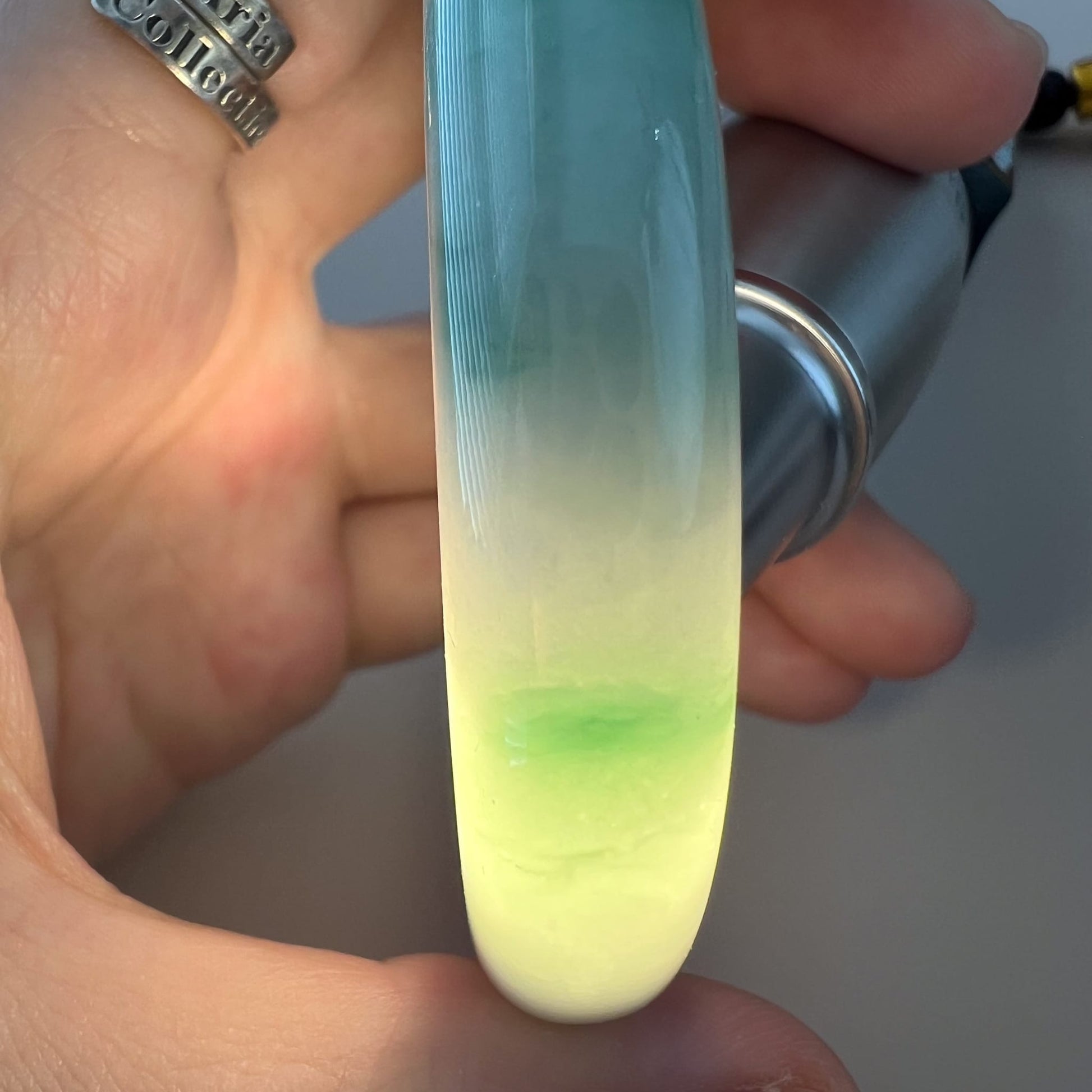 Close-up of a light green Burmese Type A jadeite bangle, showing smooth polished finish and translucent texture