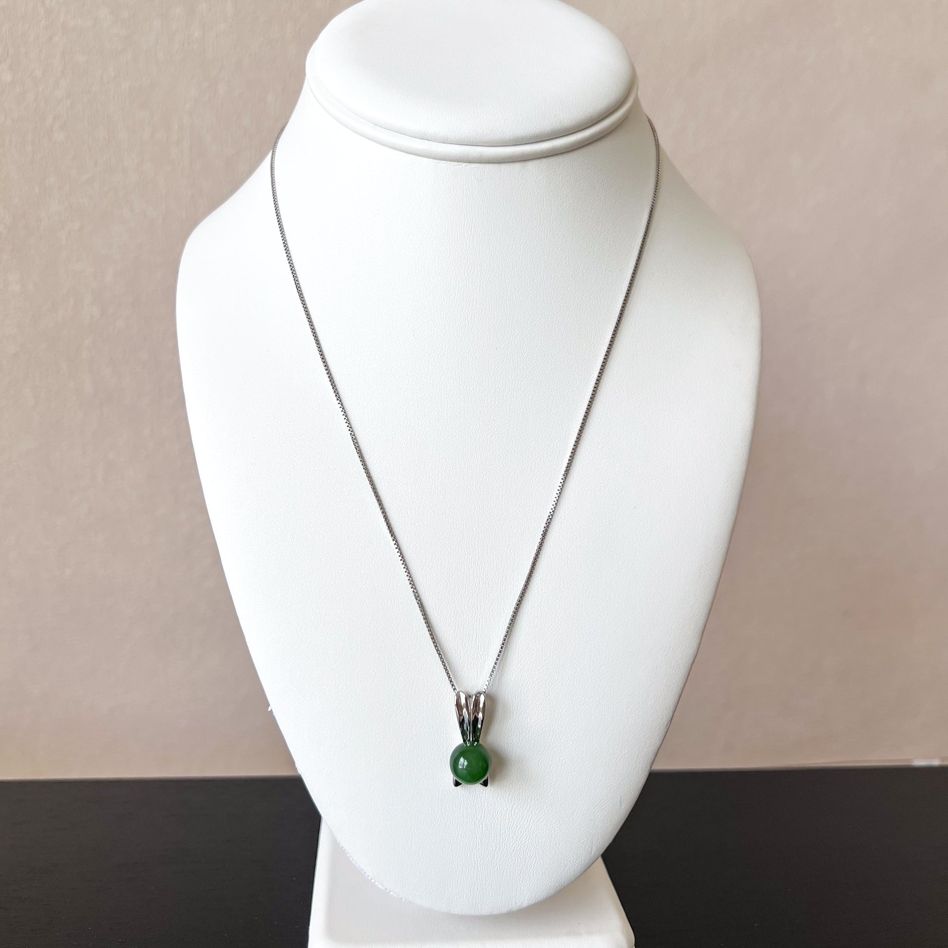 Nephrite jade rabbit pendant with bowtie on sterling silver chain, shown on white jewelry bust, polished finish