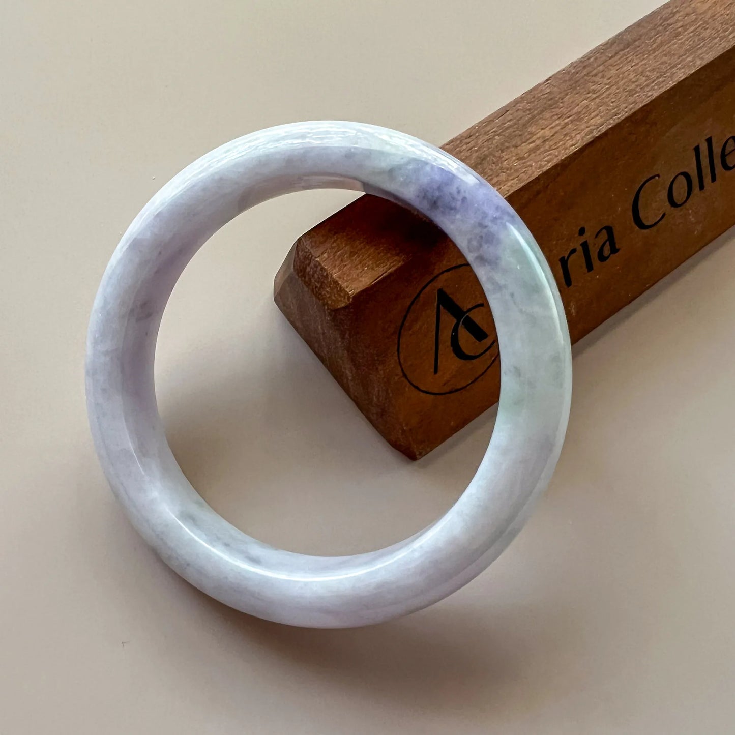 Front view of pale jade bangle with smooth polished finish and subtle lavender green marbling