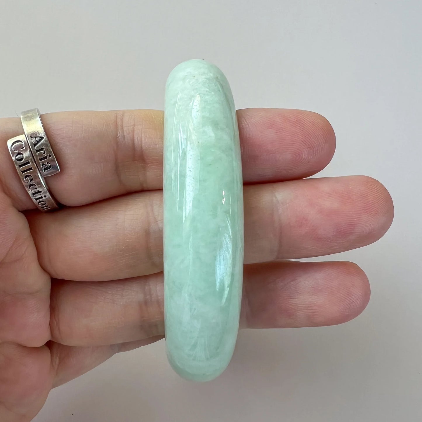 Side view of pale green jade bangle with smooth domed profile
