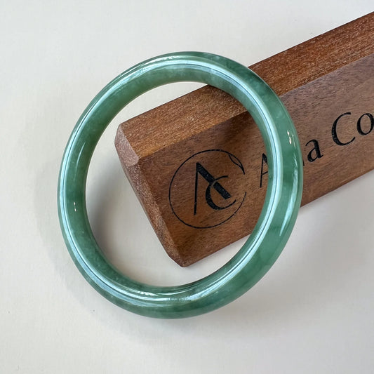 Aria Design Collection classic green jadeite bangle with a smooth round profile and high-polish finish