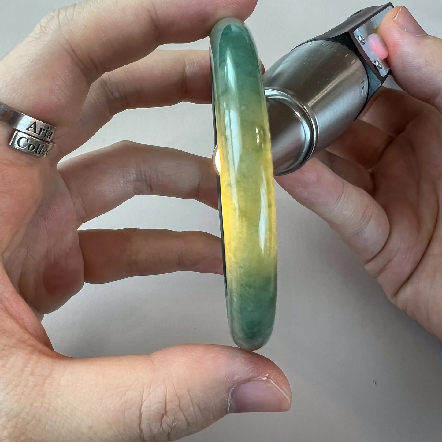 Side profile of translucent green jade bangle under flashlight illumination