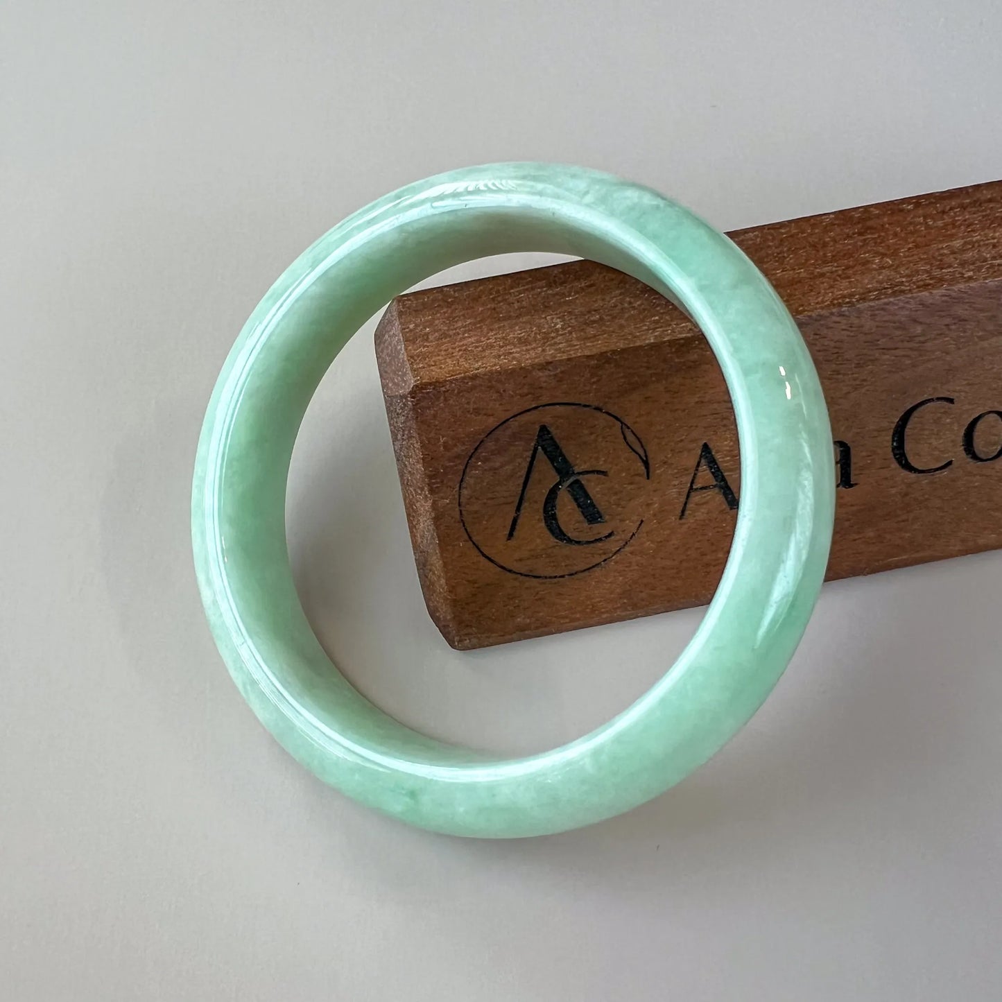 Aria Design Collection uncarved light green jadeite bangle with a rounded profile and glossy polished finish