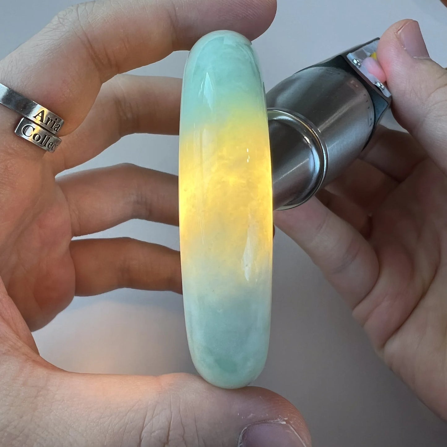 Backlit side view of jade bangle showing bright yellow-green translucency