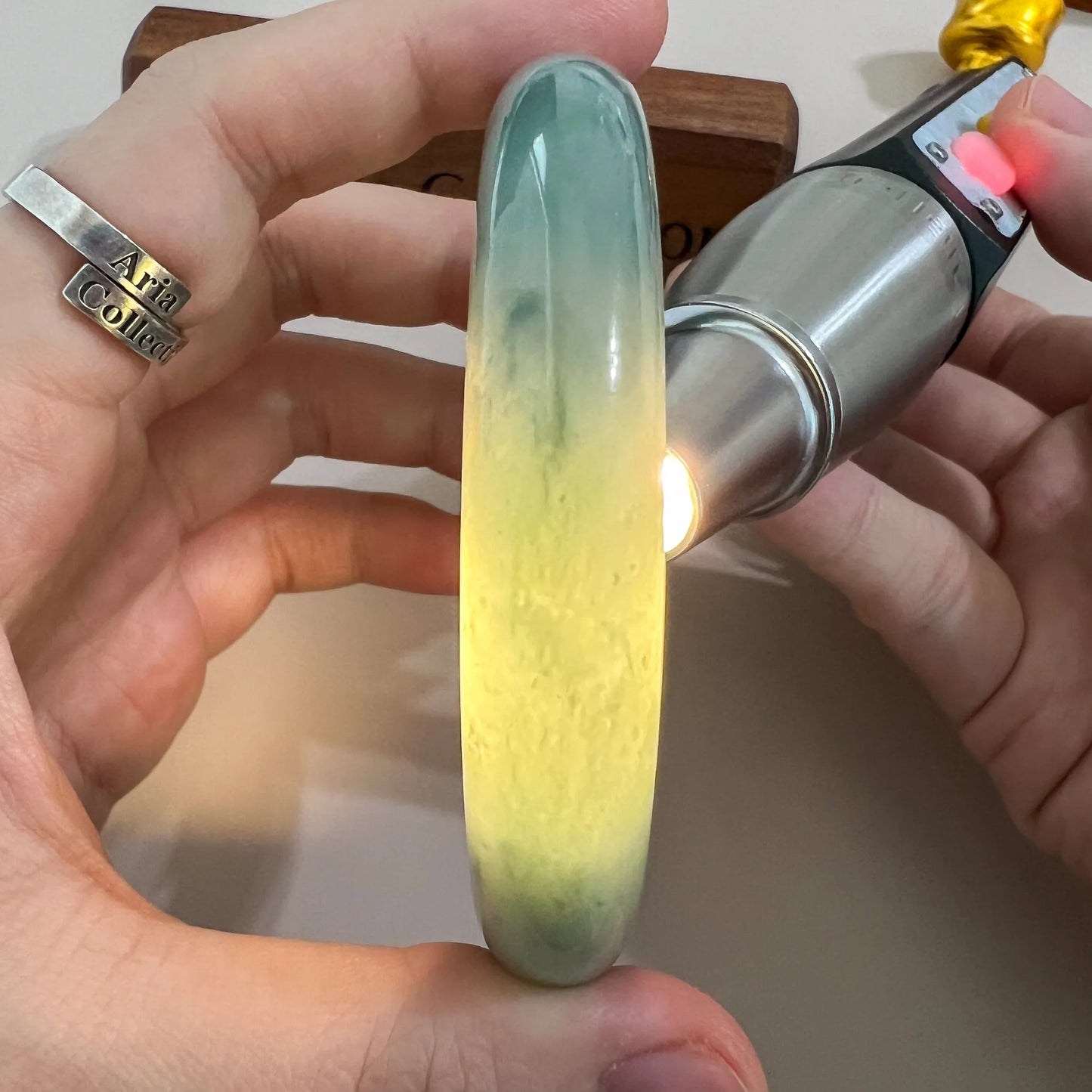Backlit side view of jade bangle with luminous yellow center and green edges