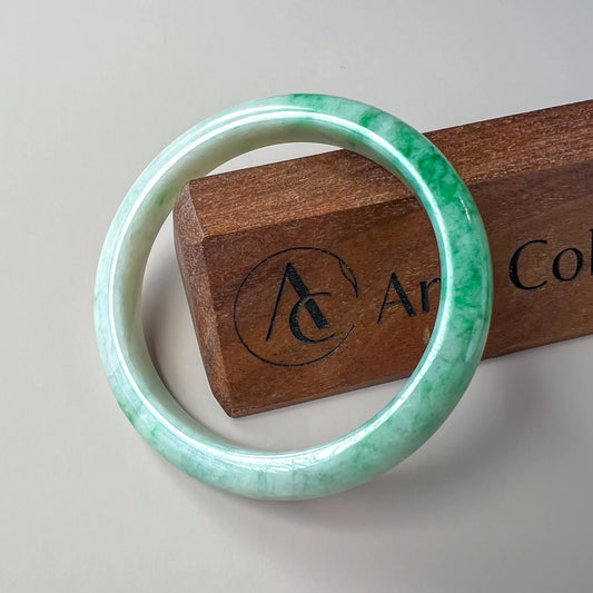 Aria Design Collection light green and white jadeite bangle with a smooth, glossy uncarved finish