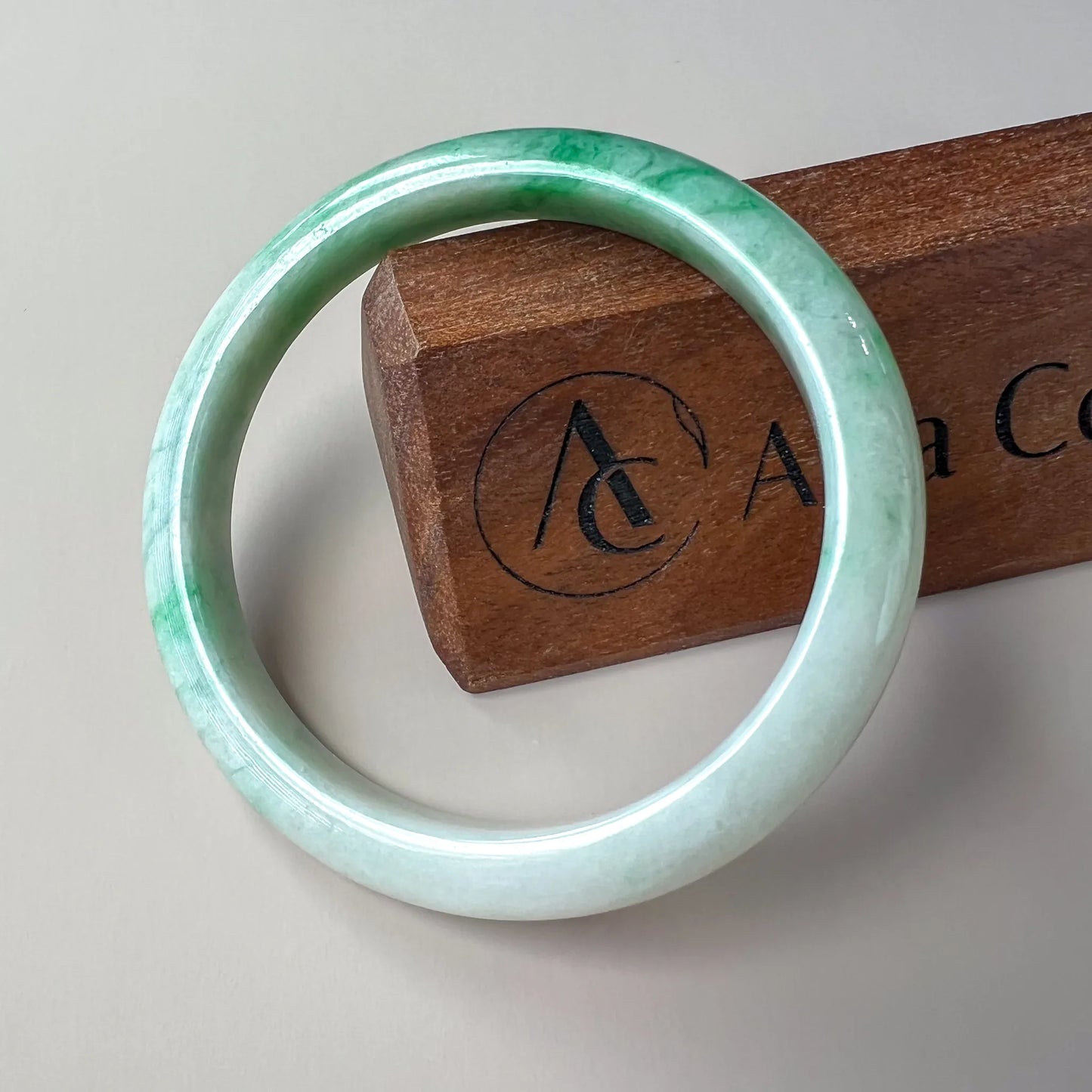 front view of green jade bangle with glossy polish on neutral display