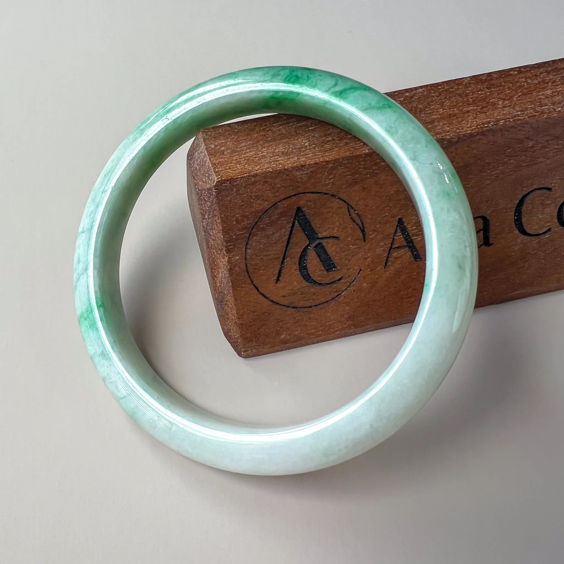front view of green jade bangle with glossy polish on neutral display