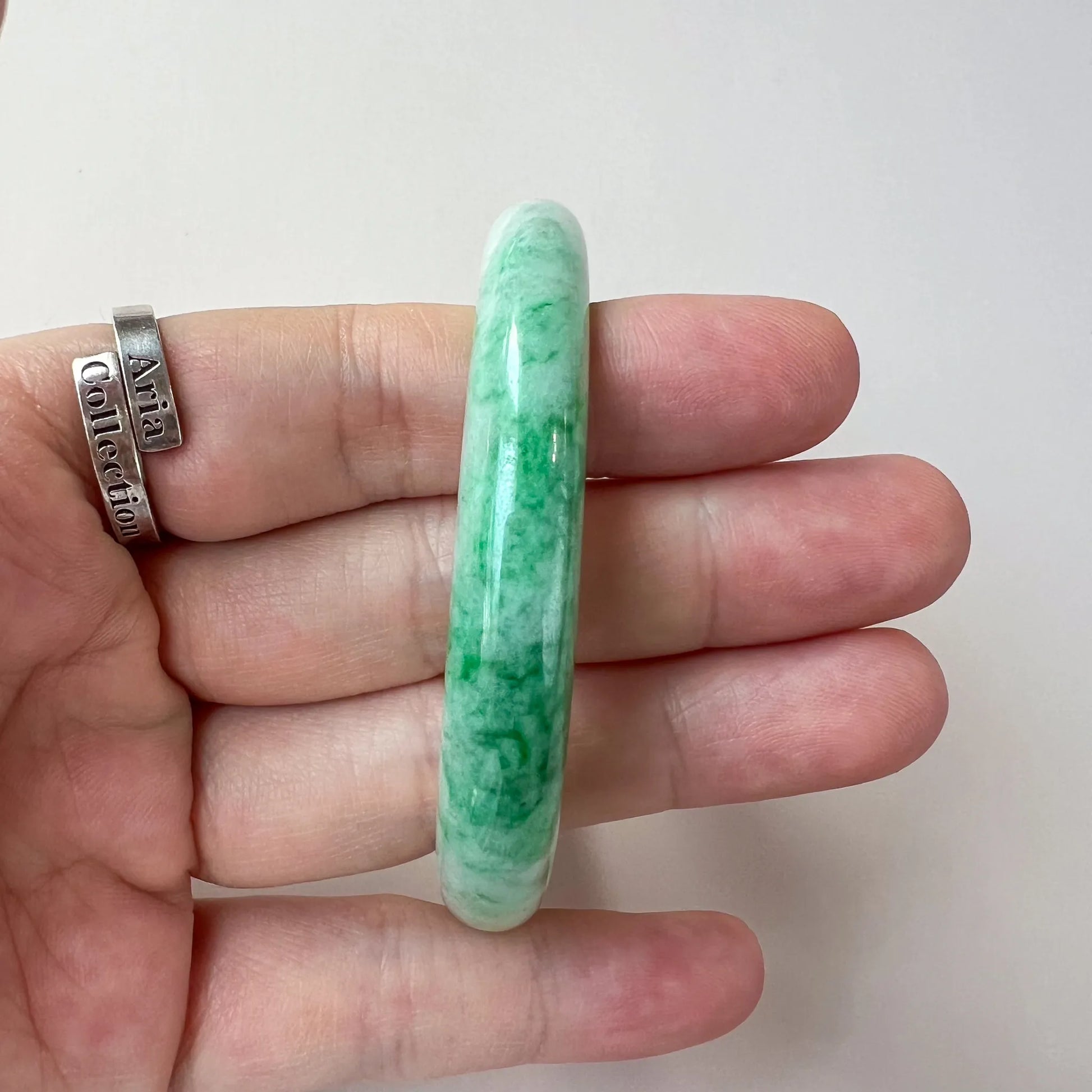 side profile of thick green jade bangle showing rounded polished edge