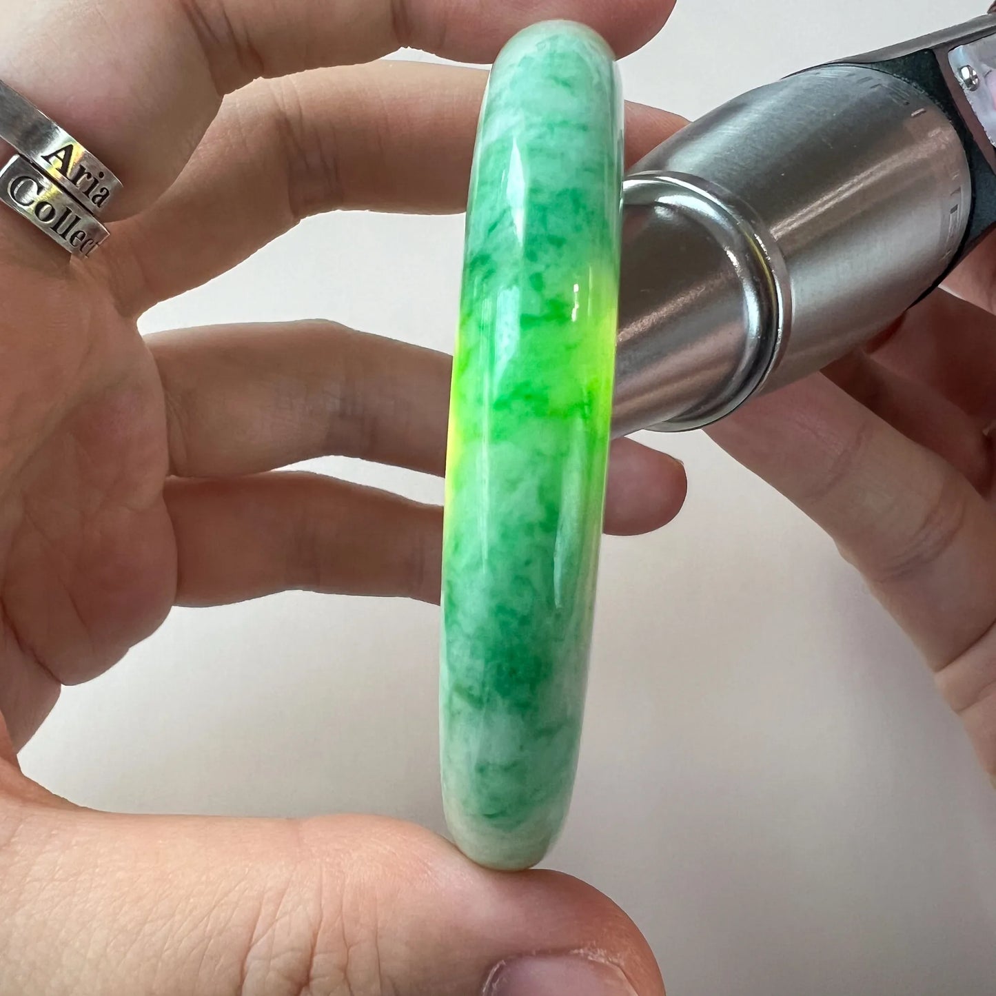 close side view of vivid green jade bangle with translucent polished finish