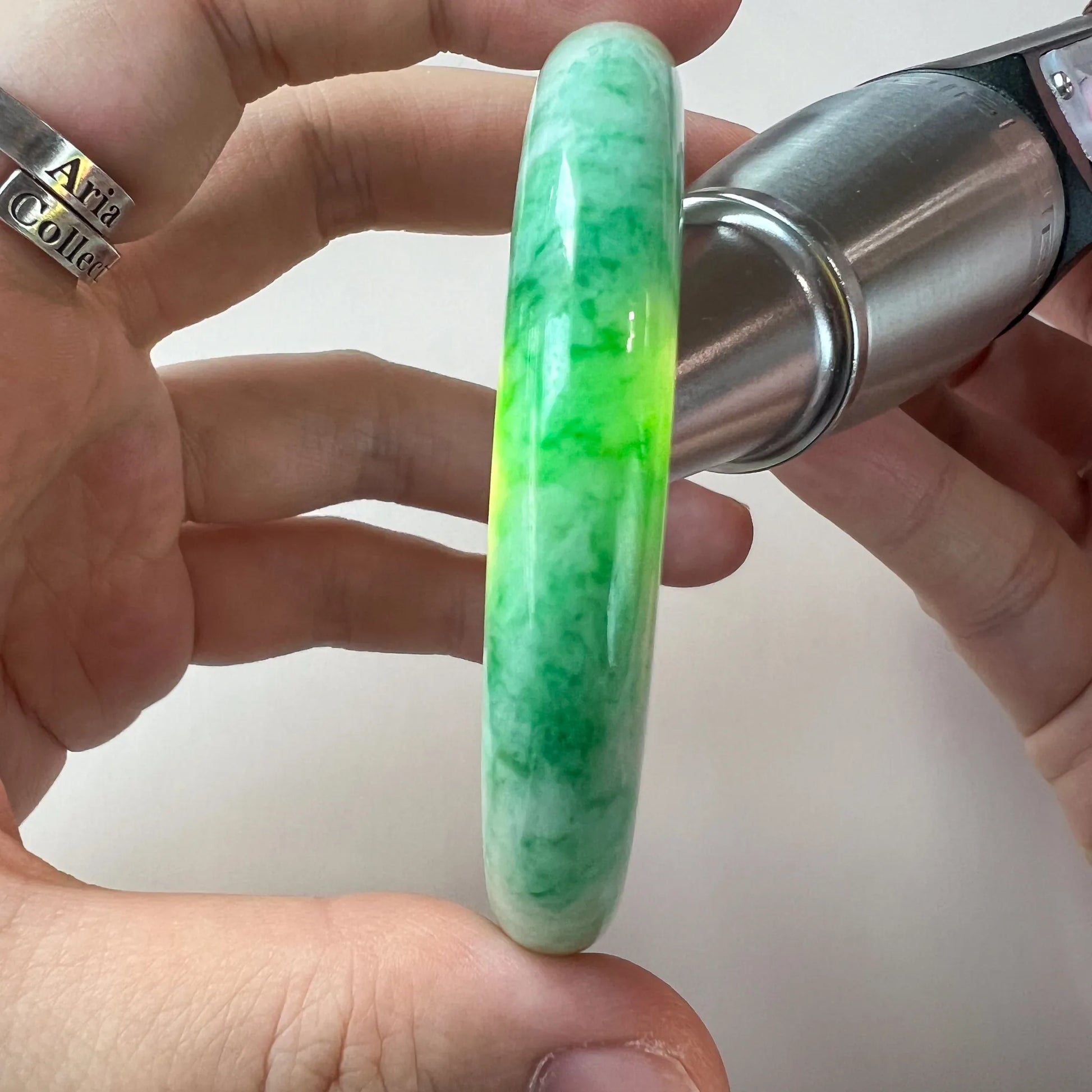 close side view of vivid green jade bangle with translucent polished finish