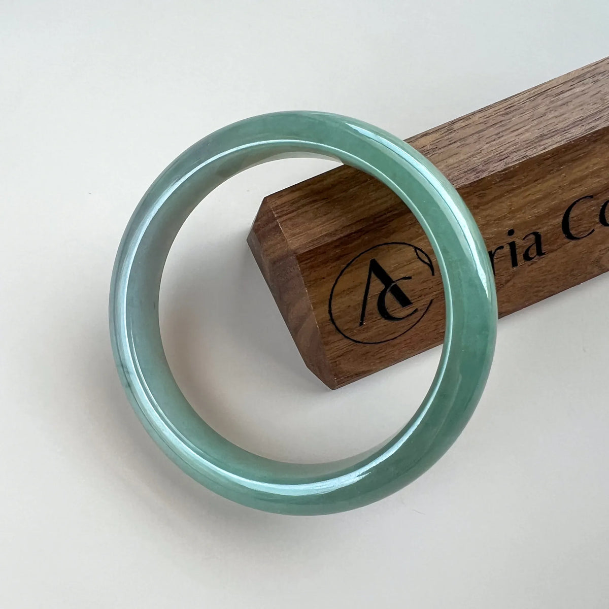 Front-facing polished jade bangle with smooth green finish on a white background