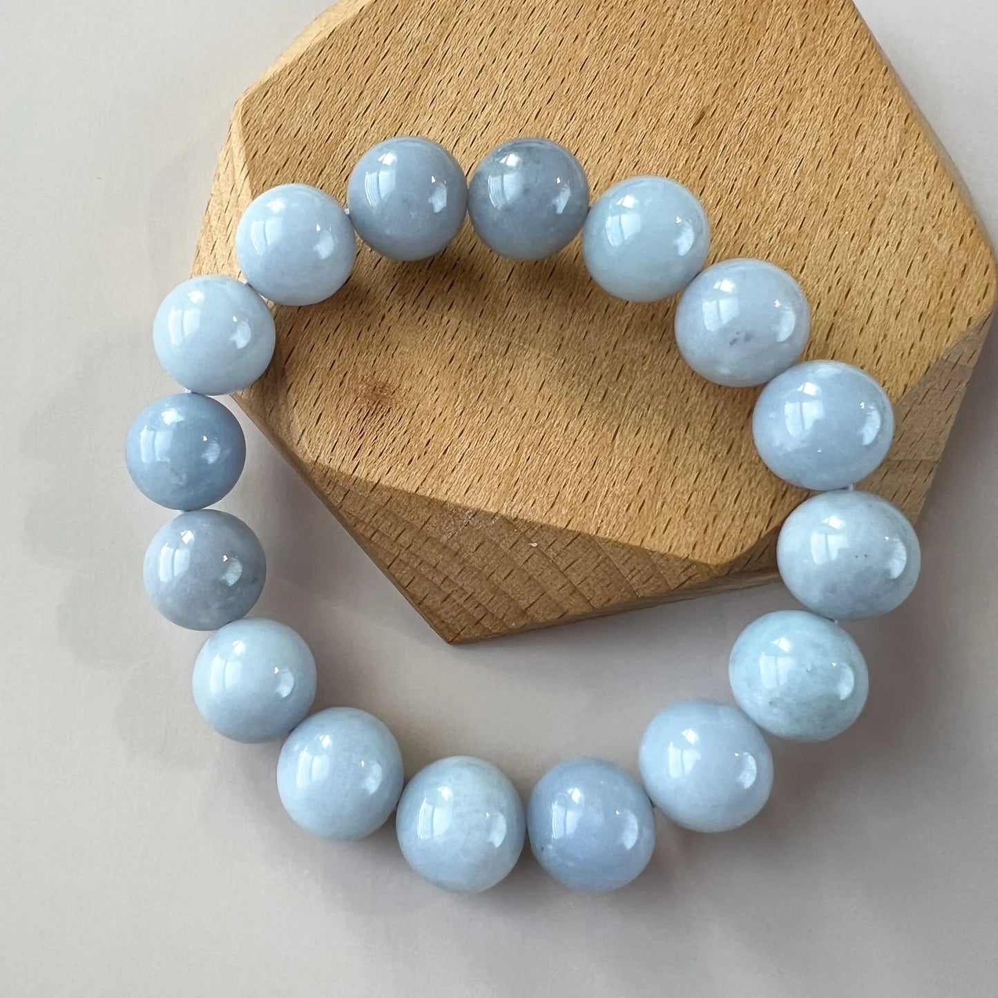 Top view of pale blue beaded bracelet on a wooden display stand