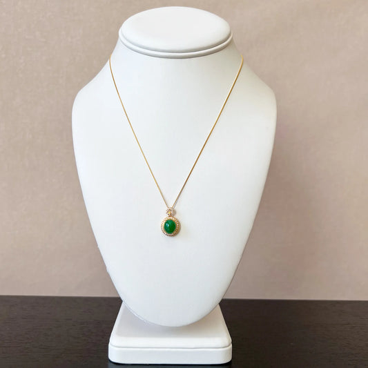 Aria Collection green natural jade oval cabochon pendant in polished gold-tone setting on necklace bust