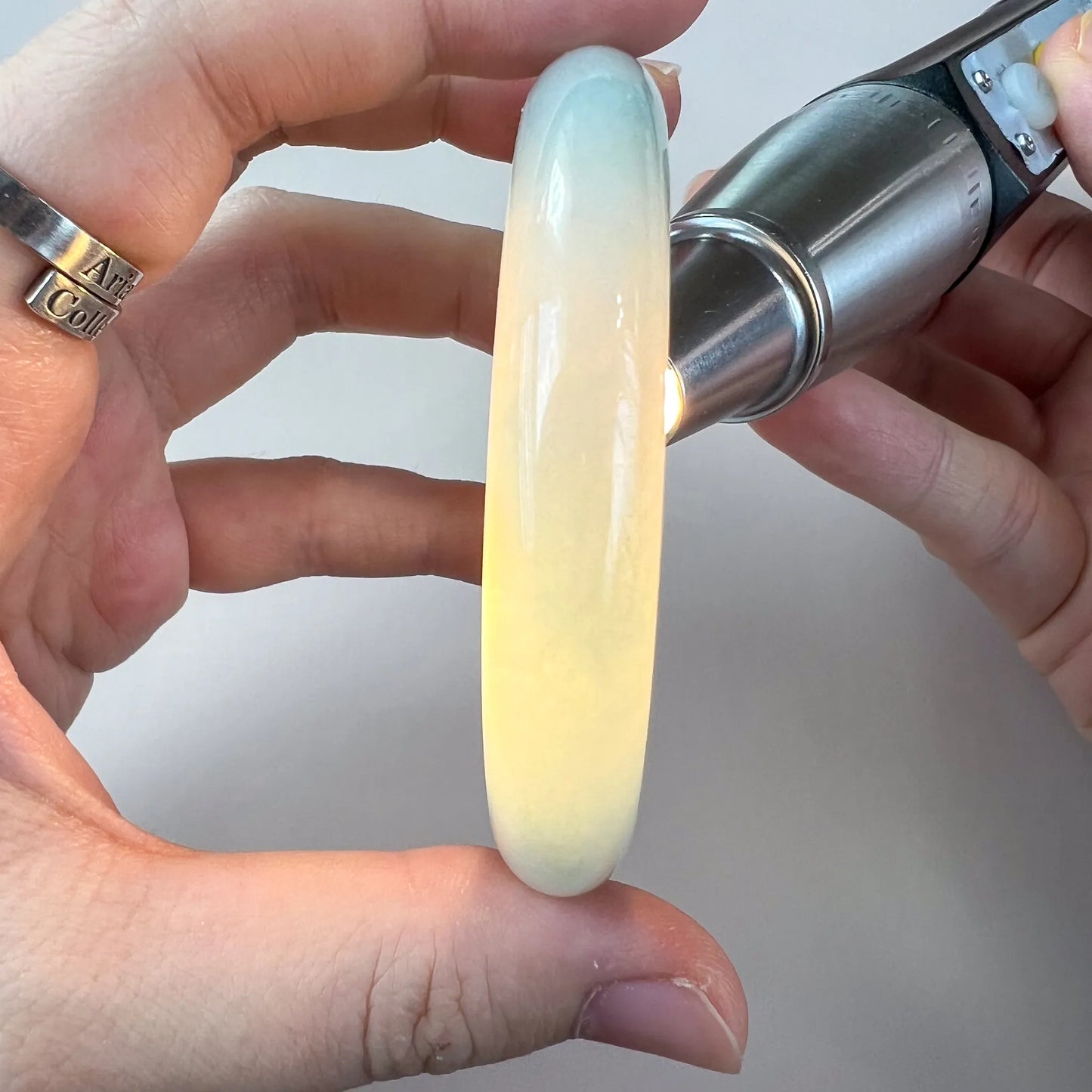 Translucent jade bangle backlit to highlight color variation and smooth polish