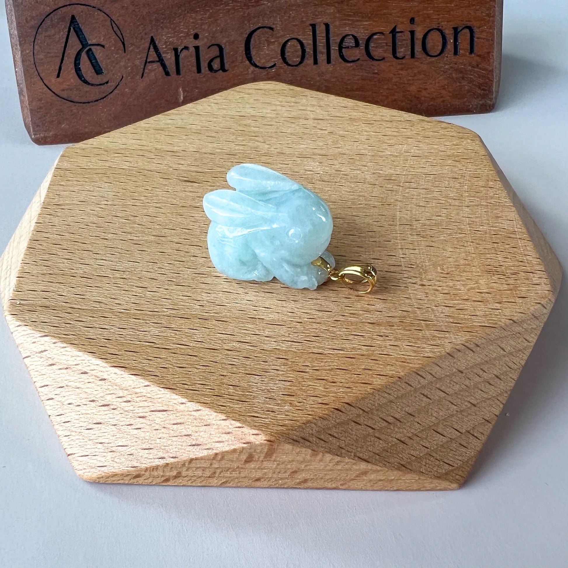 Rear side view of carved blue jade rabbit pendant with polished gold bail