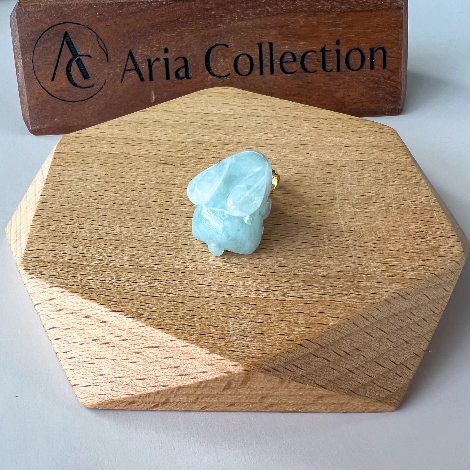 Close rear view of translucent aqua jade bunny pendant with smooth polished finish
