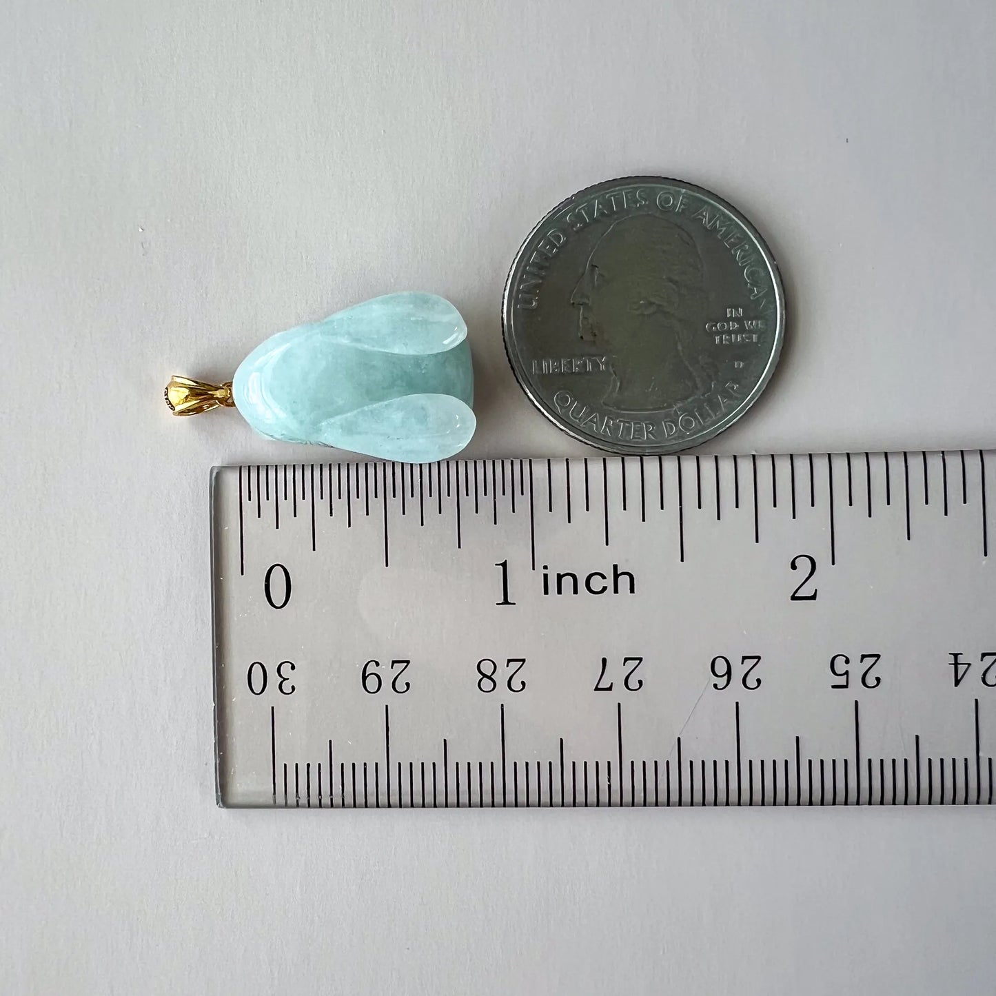 Light green jadeite jade rabbit pendant with 18K gold bail, 3D carved, shown beside coin and ruler for scale