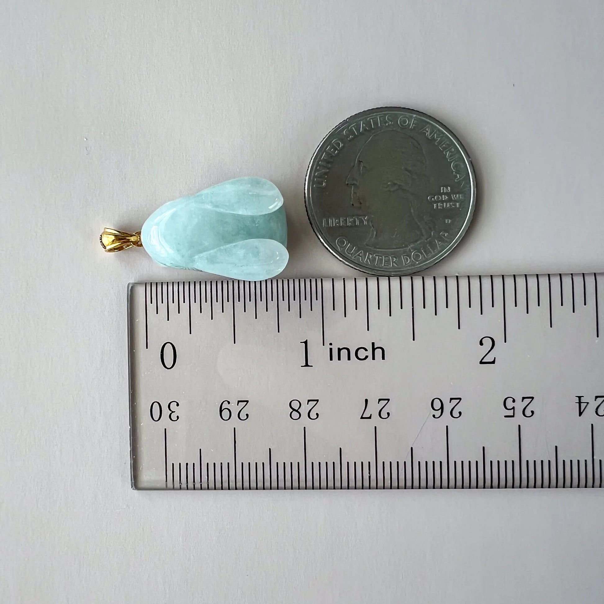 Light green jadeite jade rabbit pendant with 18K gold bail, 3D carved, shown beside coin and ruler for scale