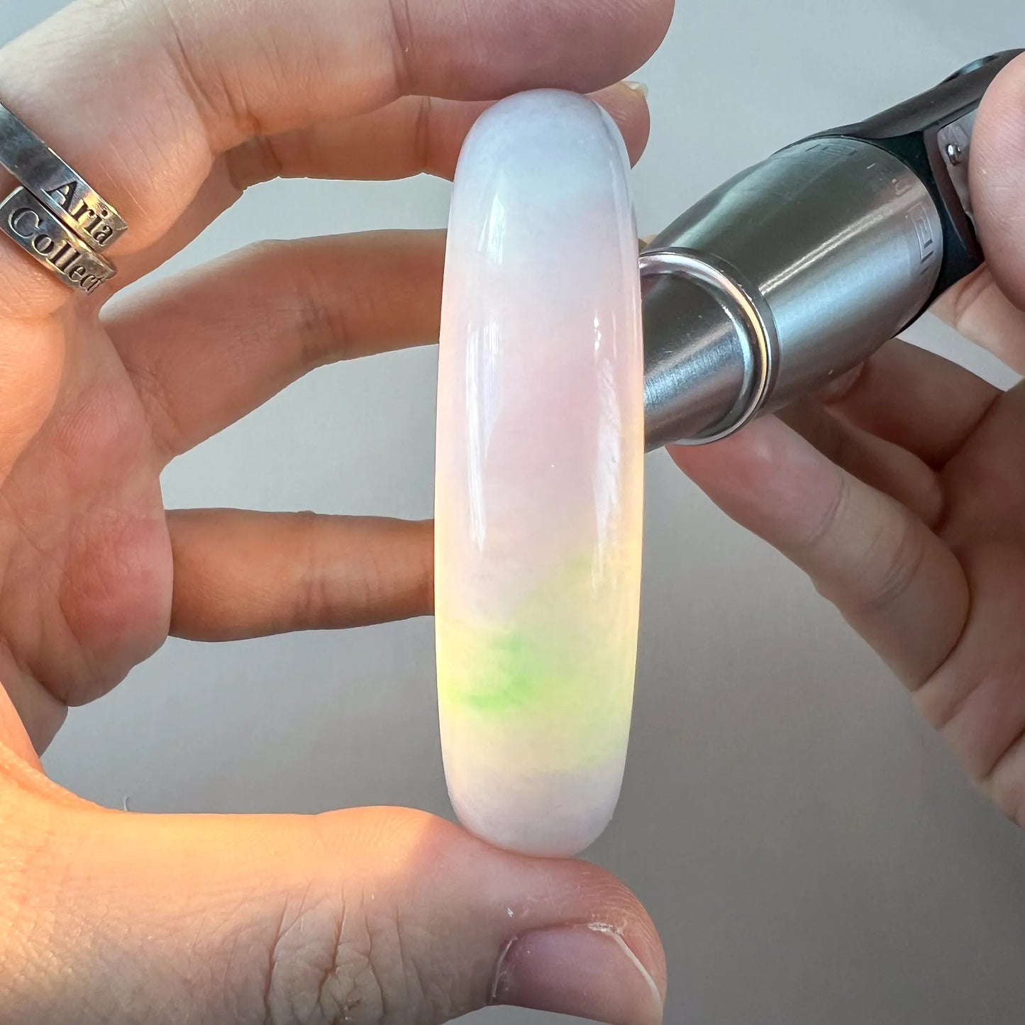 Side profile showing thick rounded bangle with translucent lavender, white, and green tones
