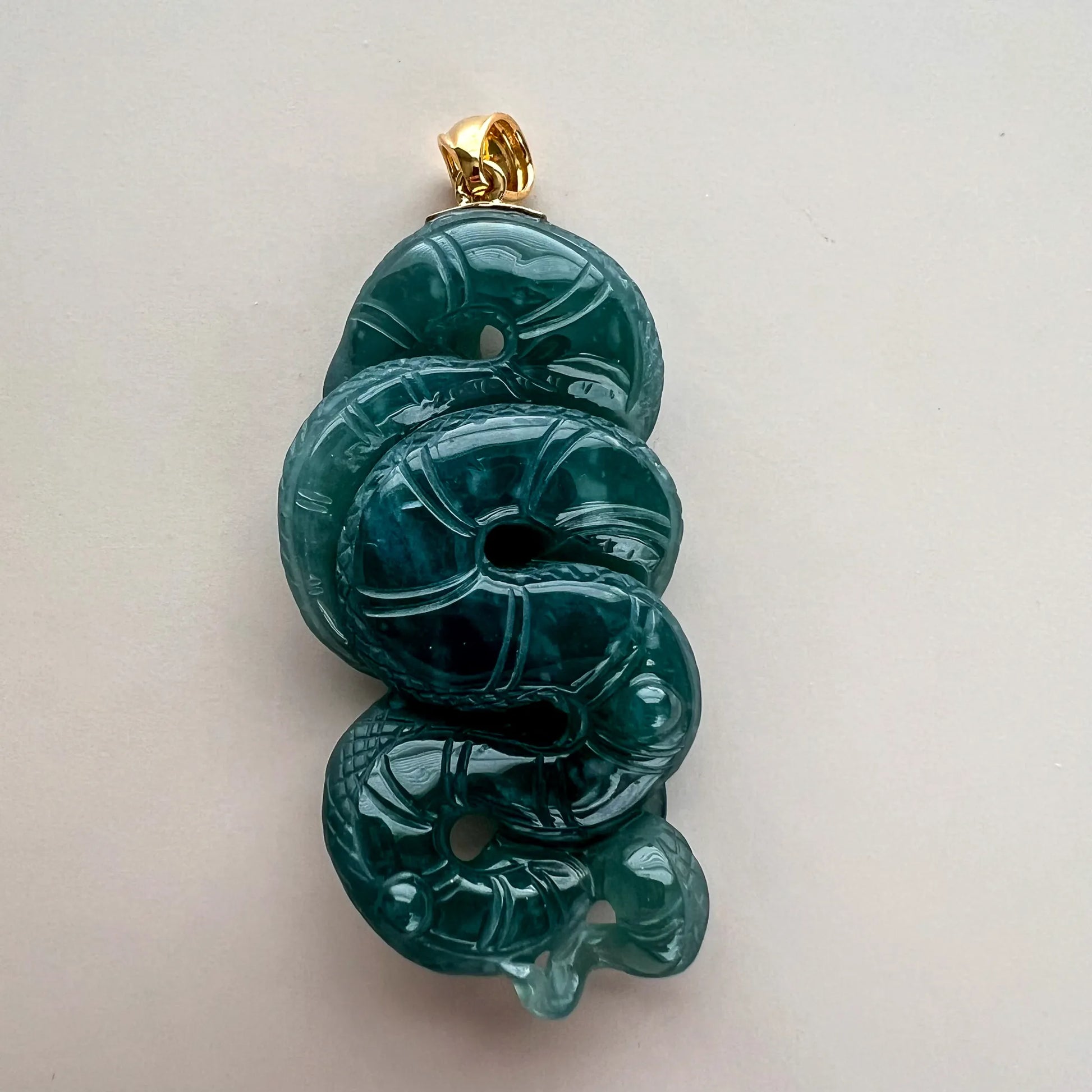 Reverse of teal-green Natural Jade snake pendant showing polished dimensional carving and gold-tone bail