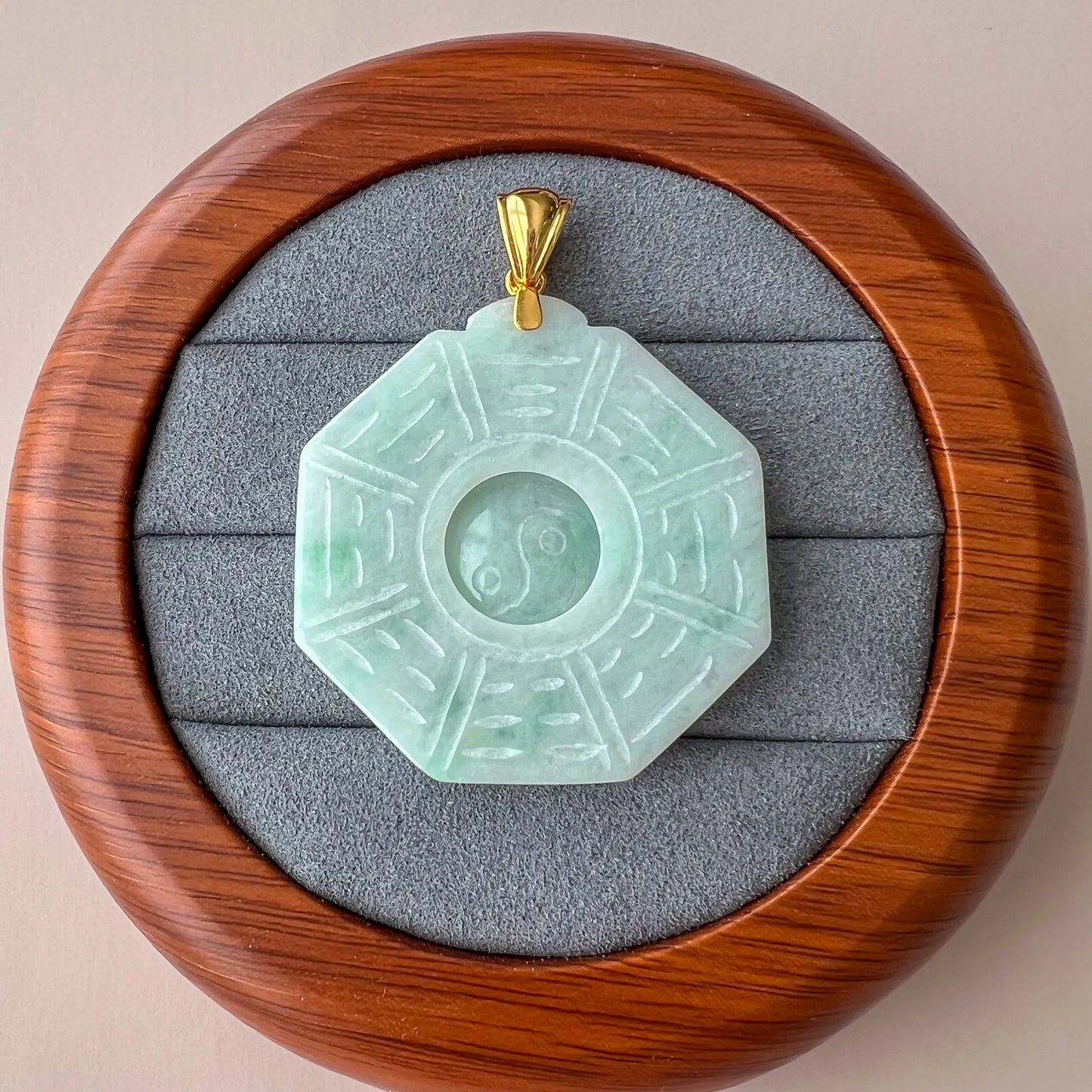 Octagonal jade pendant displayed in a velvet-lined wooden presentation box