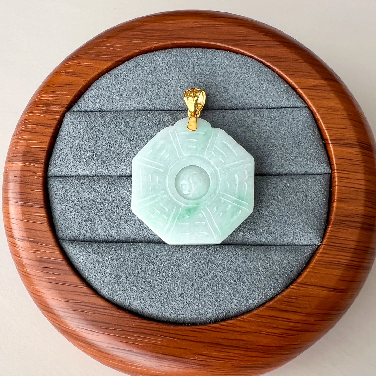 Octagonal jade pendant shown in a padded wooden presentation box