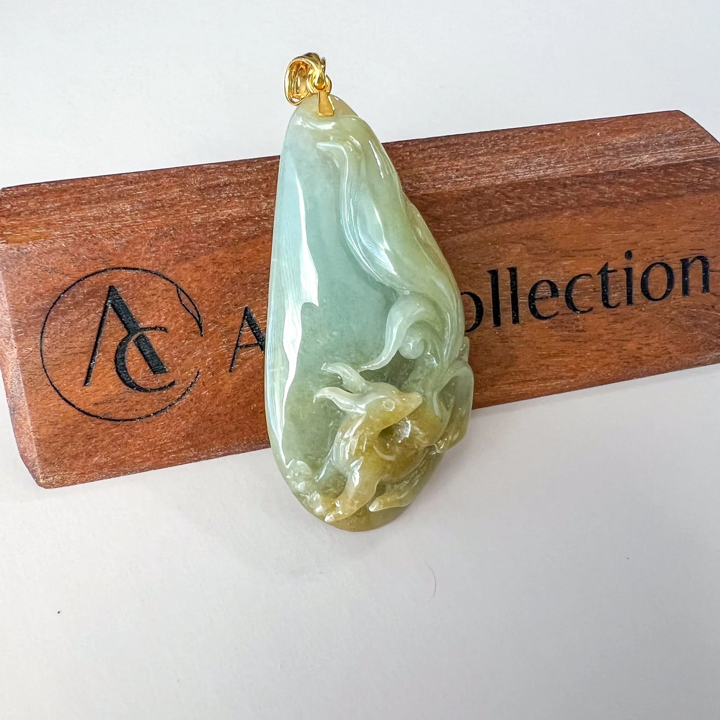 Front angled view of teardrop jade pendant with carved relief and polished finish