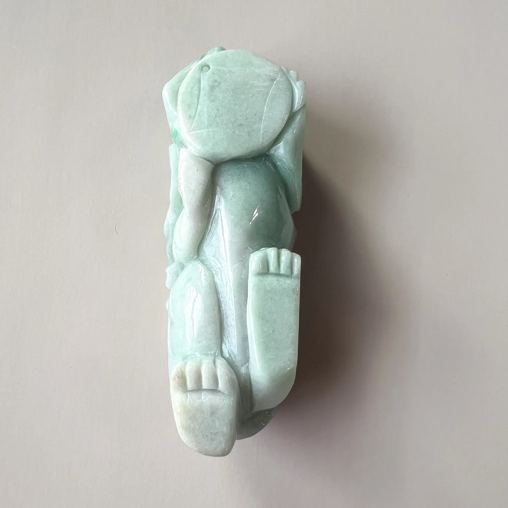 Underside view of carved jade sculpture showing base and foot details