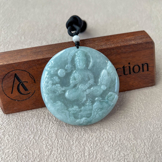 Front view of hand-carved jadeite jade Guan Yin pendant with glossy mountain landscape relief on cord necklace