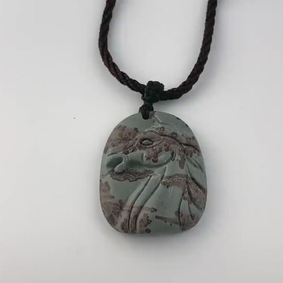 Video of a hand-carved natural jasper horse pendant in red and gray with detailed sculptural style