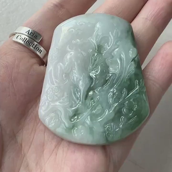 Video of a one-of-a-kind dark green jade pendant with hand-carved deer and tree, showcasing natural stone texture and artistr
