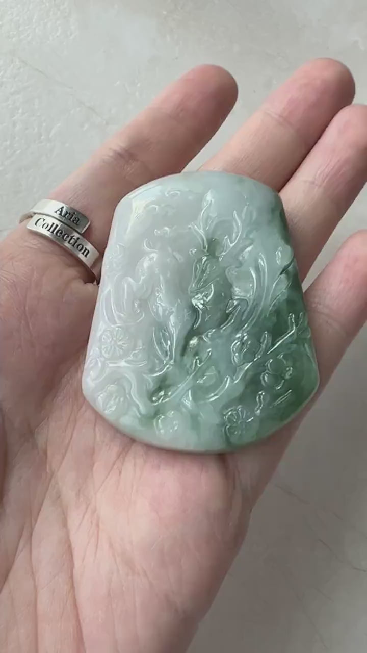Video of a one-of-a-kind dark green jade pendant with hand-carved deer and tree, showcasing natural stone texture and artistr