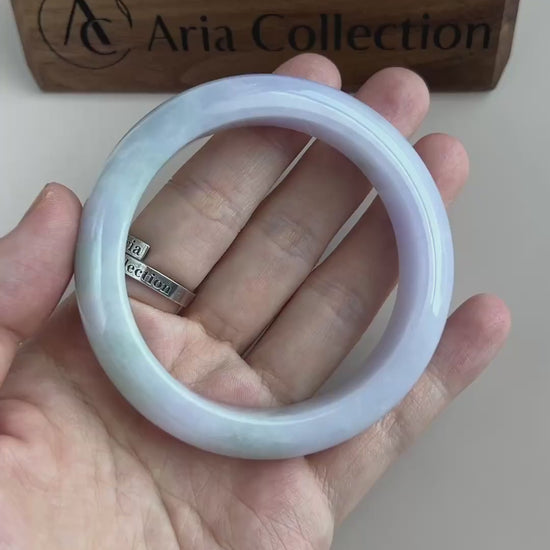 Video of a polished Burmese jadeite bangle in light green and soft lavender with translucent cloudy variations