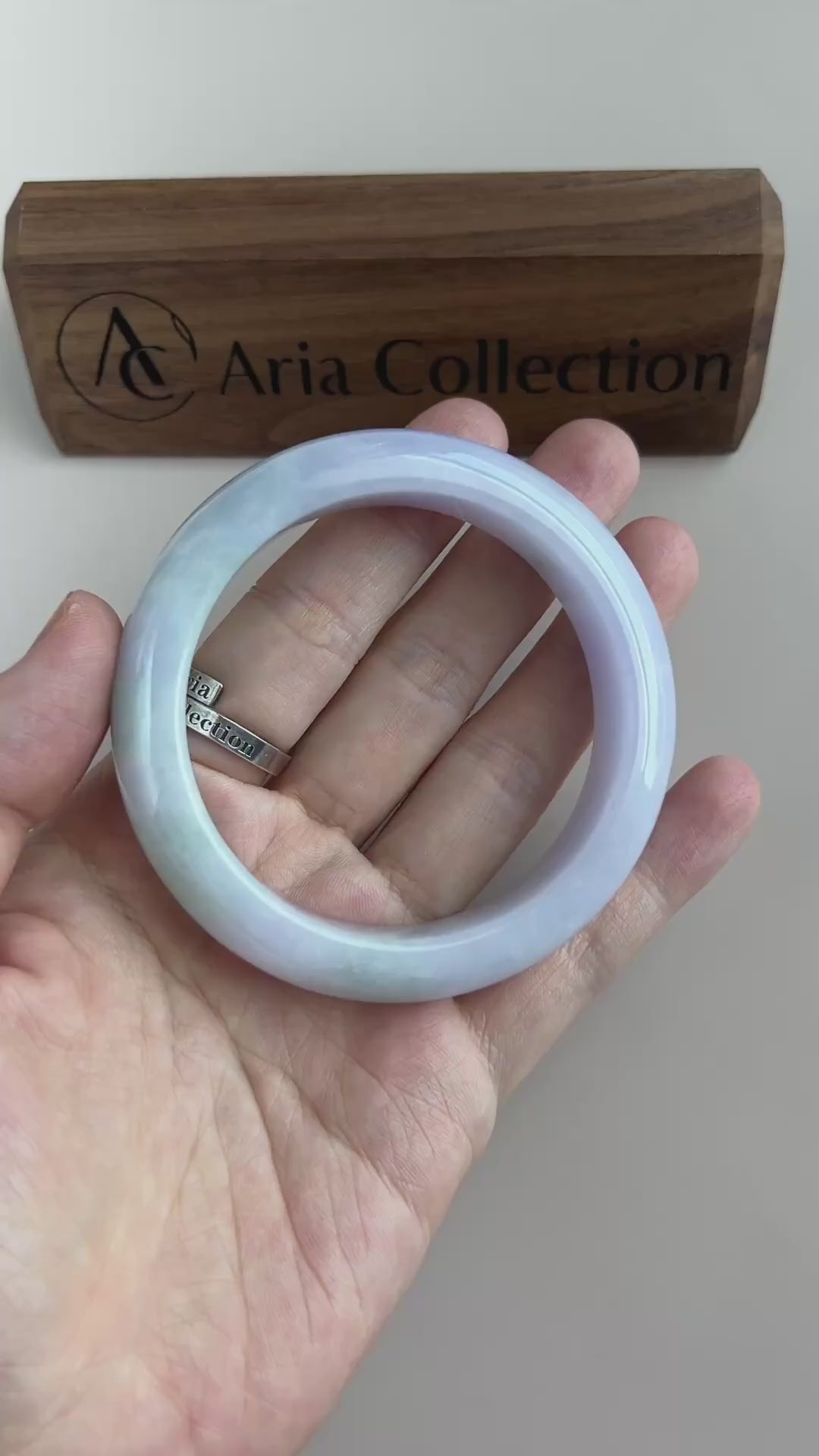 Video of a polished Burmese jadeite bangle in light green and soft lavender with translucent cloudy variations