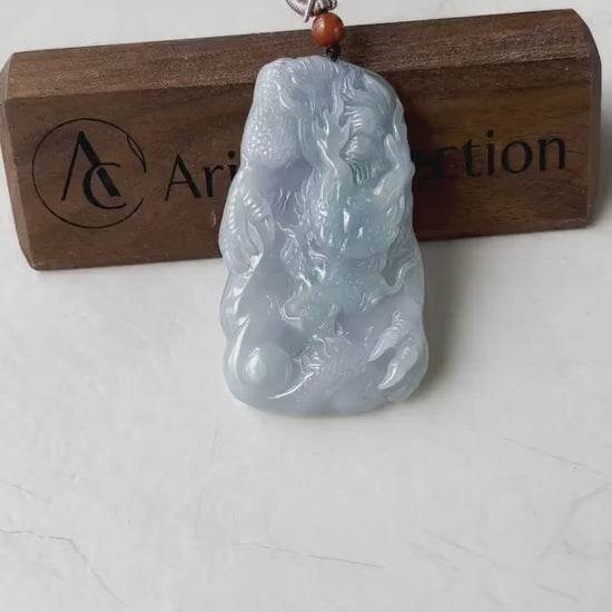 Video of a hand-carved jadeite dragon pendant in light blue and lavender with detailed mane, claws, and pearl