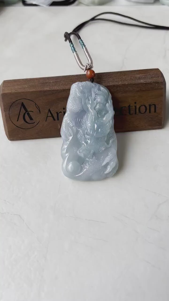 Video of a hand-carved jadeite dragon pendant in light blue and lavender with detailed mane, claws, and pearl